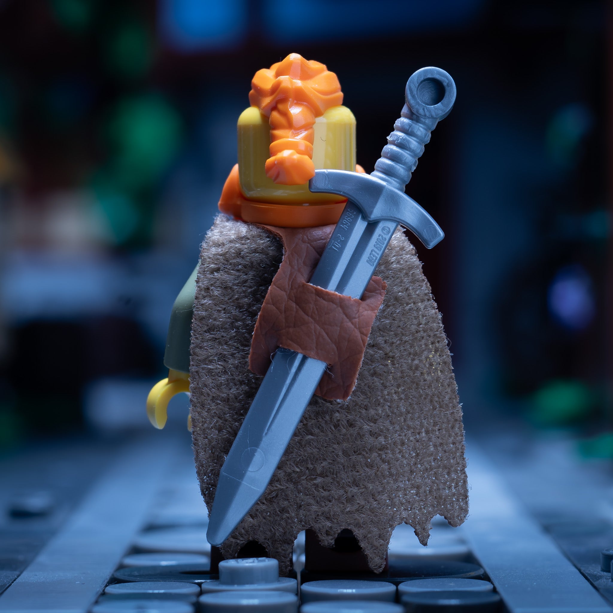 A rear view of a LEGO minifigure wearing a sword in a sheath on its back