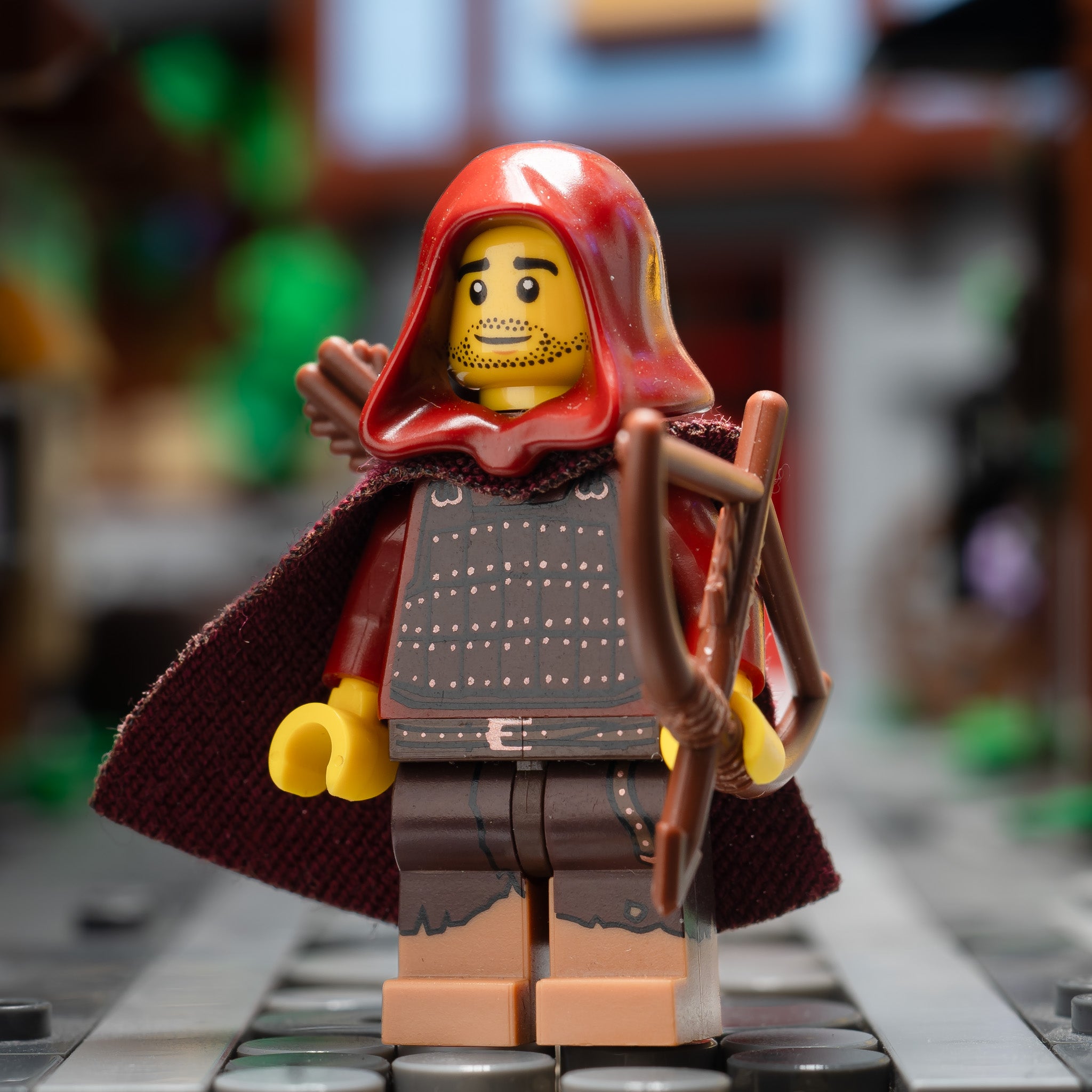 A LEGO minifigure with a red hood and armor on a blurred background